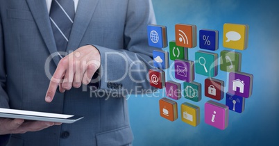 Businessman holding tablet with apps icons with blue foggy background