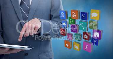 Businessman holding tablet with apps icons with blue foggy background
