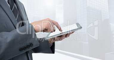 Businessman touching tablet by bright window