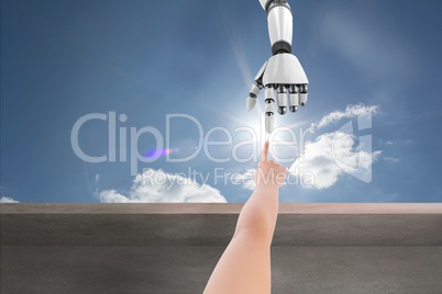 Human hands touching robot hand in blue sky background