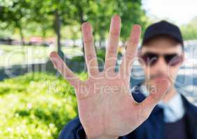 blurred security guard saying stop with his hand in the park