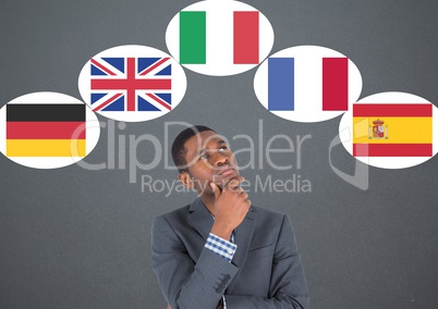 main language flags around businessman thinking. Dark grey background