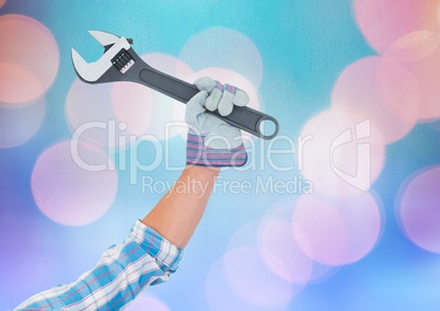 Hand holding wrench with sparkling light bokeh background