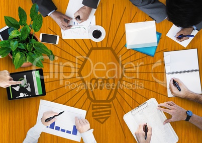 Overhead of business team with yellow wood panel and lightbulb doodle