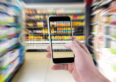 Hand of person taking a picture of supermarket bottles  with her smartphone