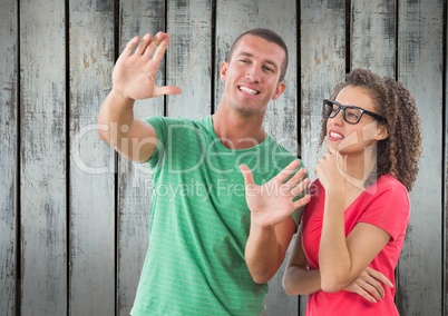 A man showing something to a girl in front of wood wall