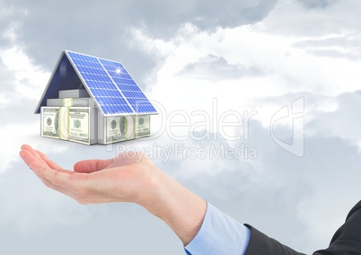Digital composite image of currencies and solar panel above business hand against sky
