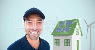 Delivery man standing by house and windmill against blue background