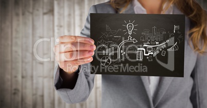 Business woman mid section with black card showing white business doodles against blurry wood panel