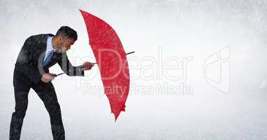 Business man blocking rain with umbrella against white background