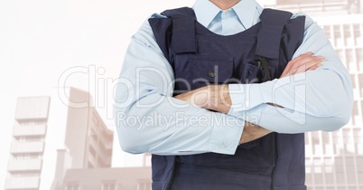 Security guard mid section arms folded against faded buildings