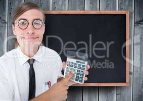 Man looking up with calculator against chalkboard and grey wood panel