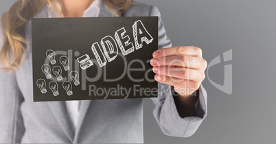 Business woman mid section with black card showing white idea doodle against grey background