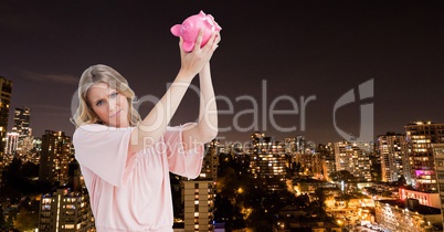 Broke woman with piggy-bank trying get money with the city at night background