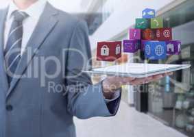 Businessman holding tablet with apps in shopping mall