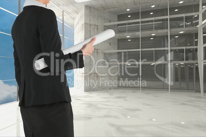 Architect holding plan against room background