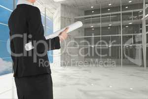 Architect holding plan against room background