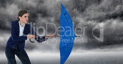 Business woman with umbrella and blocking rain against storm clouds