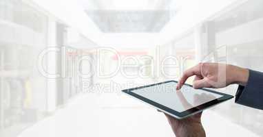 Businessman touching tablet in bright shopping mall