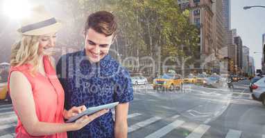 Trendy man and woman with tablet against sunny street with flares