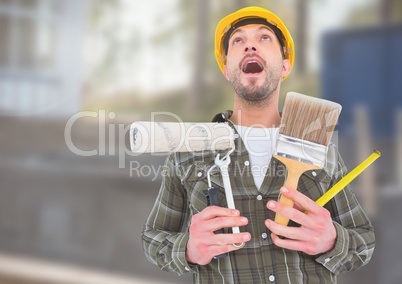 Construction Worker with paint tools in front of construction site