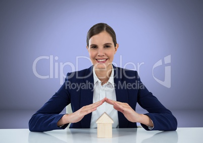 Woman protecting house model with hands