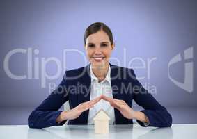 Woman protecting house model with hands
