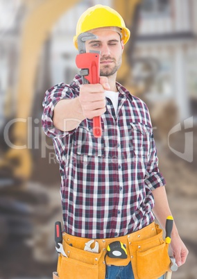 Construction Worker with tool in front of construction site