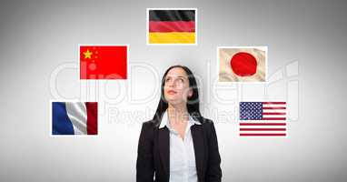 Businesswoman standing by flags against gray background