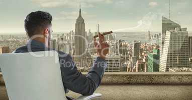 Rear view of businessman sitting on chair and looking at city while smoking cigar