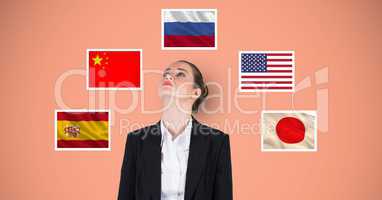 Businesswoman standing by various flags against orange background