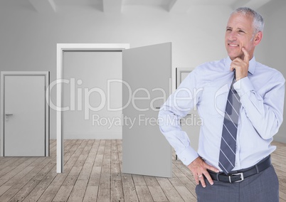 Mature businessman standing on hardwood floor against doors
