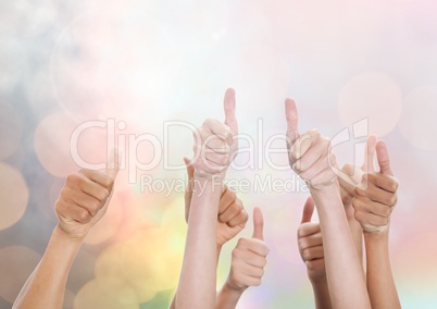 Lots of Hands thumbs up with sparkling light bokeh background