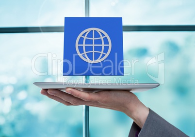Businesswoman holding tablet with World global app icon by window