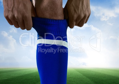 soccer player putting well his blue shock, sky and field back