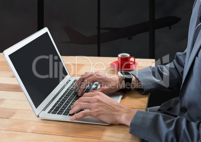 Businessman using laptop in dark airport