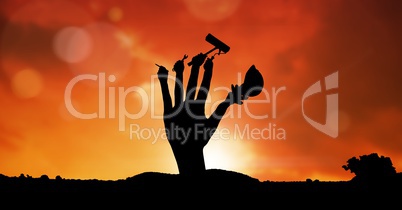 Digital composite image of hand with tools against sky during sunset