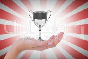hand holding trophy against linear red and white background