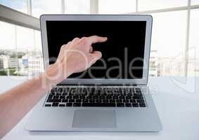 Hand pointing at laptop with windows