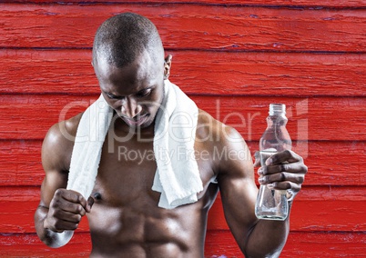 fitness man with water and towel with red wood background