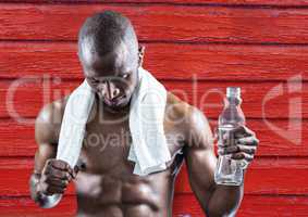 fitness man with water and towel with red wood background