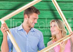 couple with frame with green wood background