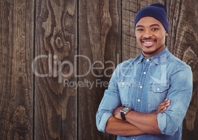 Casual man with wooly hat standing on ahead a wood wall