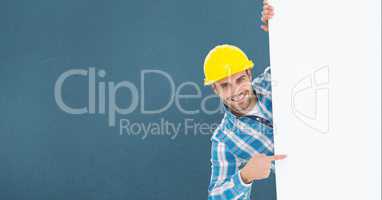 Portrait of smiling male architect pointing billboard while standing against blue background