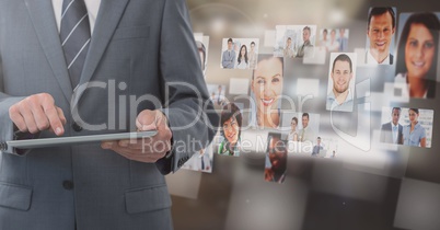 Businessman holding tablet with people's profile pictures in office