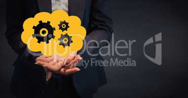 Business woman mid section with yellow cloud and gear graphic in hands against navy background