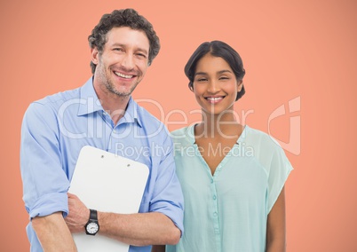 Two people smiling to the photo with a salmon background