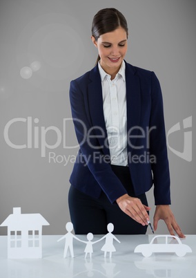 Woman with cut outs of  house family and car insurance