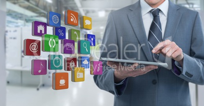 Businessman holding tablet with apps  in long room space