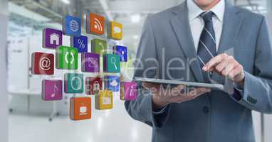 Businessman holding tablet with apps  in long room space